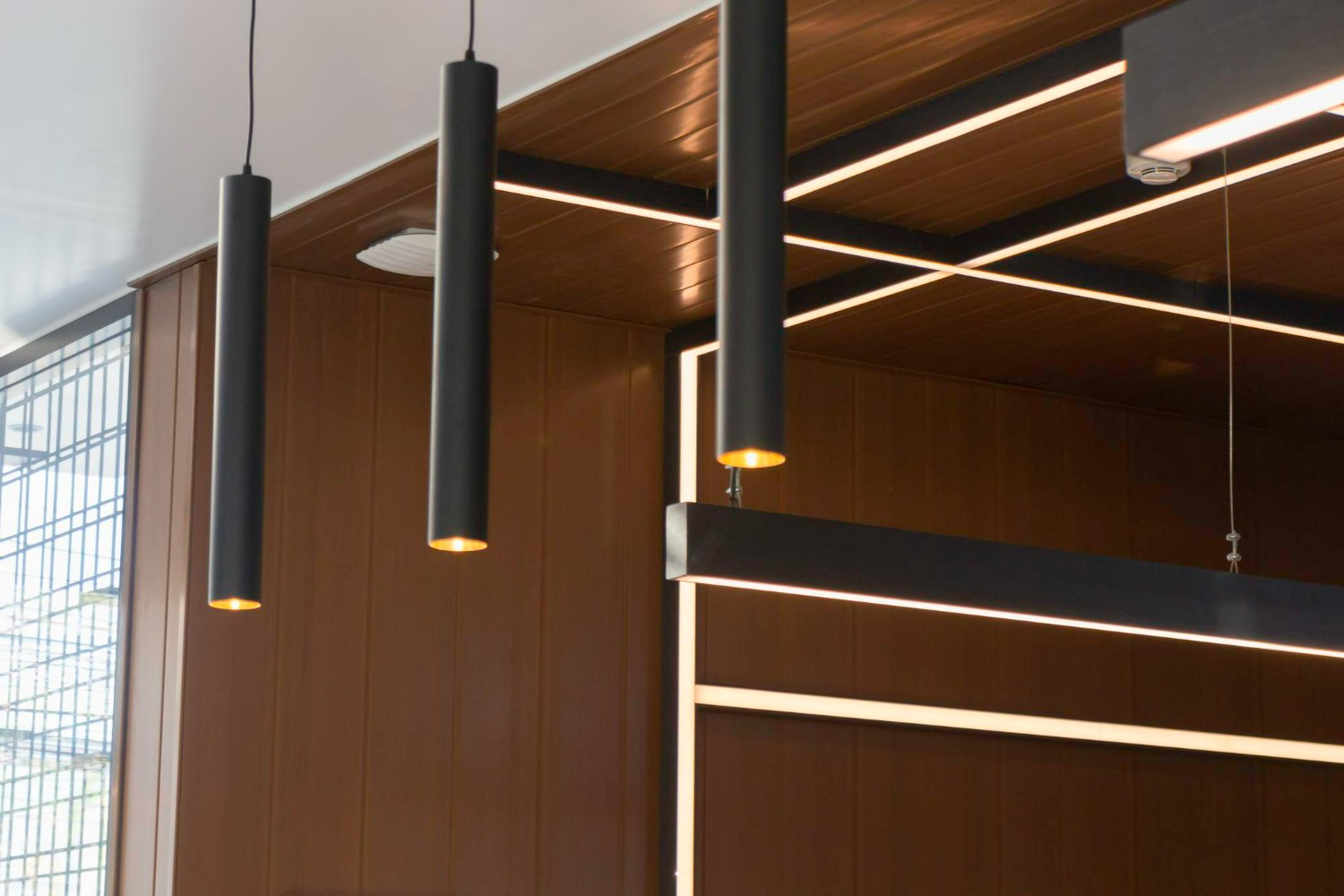 Contemporary living room with sleek spotlight ceiling lights illuminating artwork and furniture. 